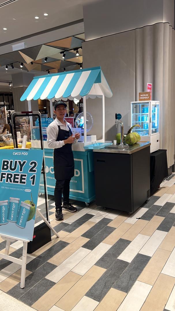 Cocopod branded kiosk with staff and shoppers in a mall